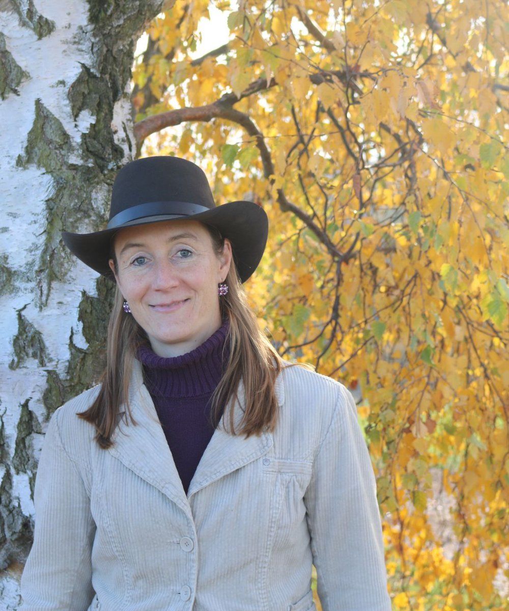 Dr. Julia Mack-Heil steht vor einem Baum im Herbst.